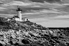 Eastern Point Lighthouse Over Rocky Shore in Gloucester, MA -BW